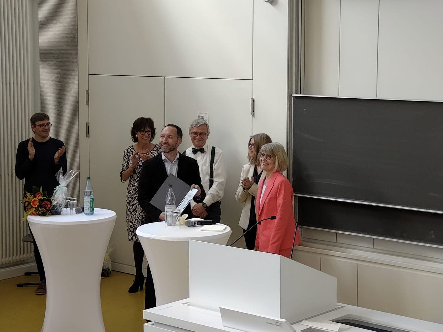 Erster Lehrpreisträger Prof. Guido Reuther (Mitte). (Foto: HTWK Leipzig) Menschen an Stehtischen in Hörsaal