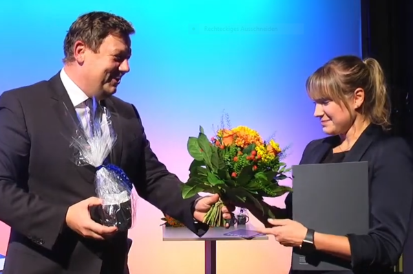 Die Preise des HTWK-Fördervereins 2019 wurden pandemiebedingt während einer (fast ausschließlich) virtuellen Veranstaltung verliehen. Prof. Markus Krabbes übergibt den Preis an Marie-Louise Heinich. (Foto: HTWK Leipzig) Mann übergibt Frau einen Blumenstrauß und beglückwünscht sie