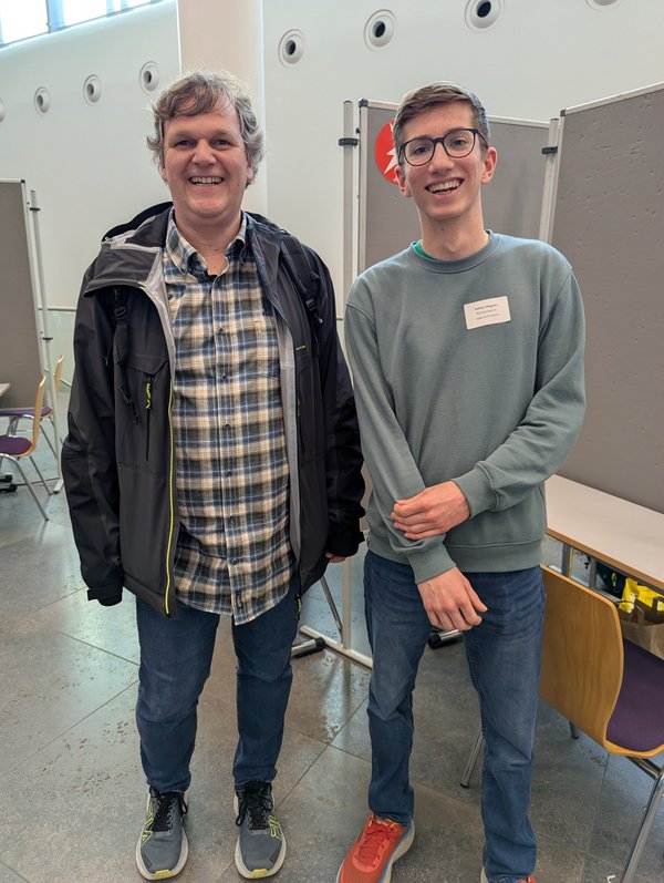 zwei unterschiedlich alte Männer lachen in die Kamera