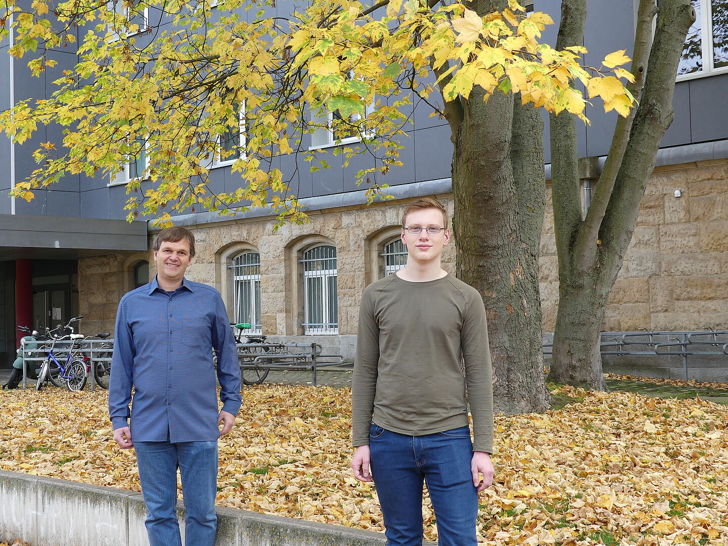 Prof. Jochen Merker (links) und Benjamin Kunsch. (Foto: MNZ/HTWK Leipzig) Zwei Männer unter herbstlichem Baum.
