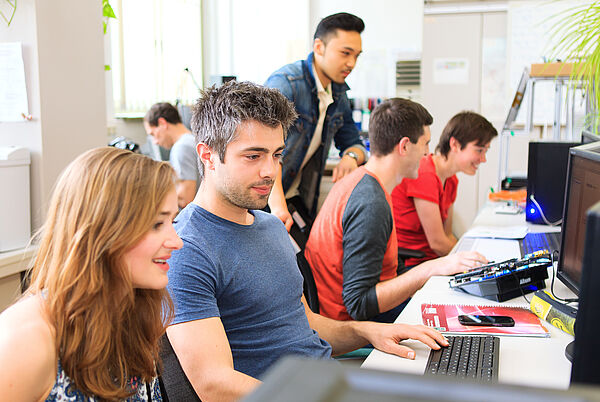 Junge Menschen sitzen vor Computern.