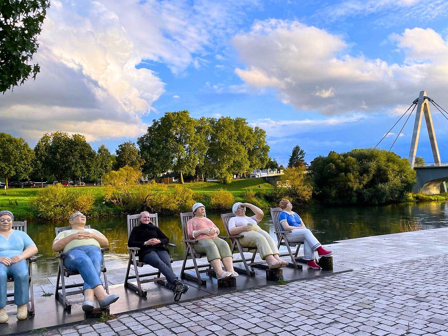 Eine Frau sitzt zwischen Skulpturen