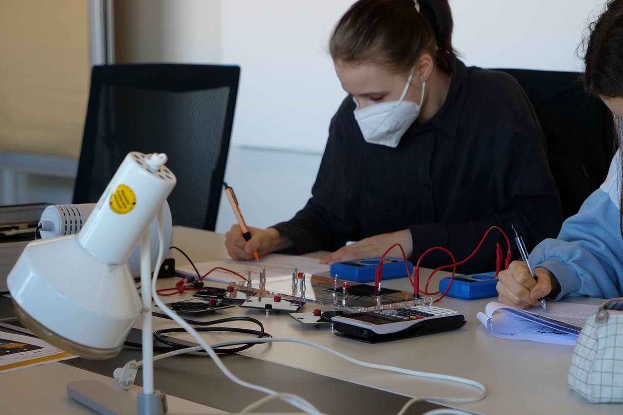 Foto von Schülerin mit Gesichtsmaske bei der Arbeit